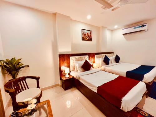 a hotel room with two beds and a chair at Sandhya INN in Rishīkesh