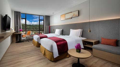 una camera d'albergo con due letti e un divano di Holiday Inn Batang, an IHG Hotel a Batang