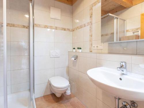 a white bathroom with a toilet and a sink at Zillertalarena 148 in Krimml