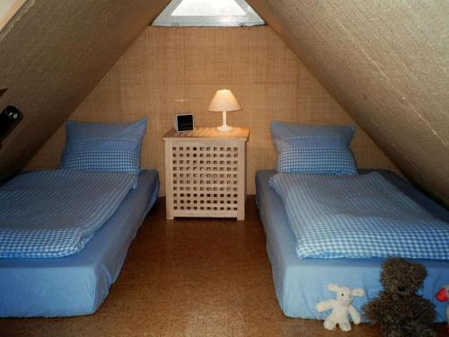 ein Schlafzimmer mit 2 Betten und einem Tisch mit einer Lampe in der Unterkunft De Höller - Dakappartement met Toren 