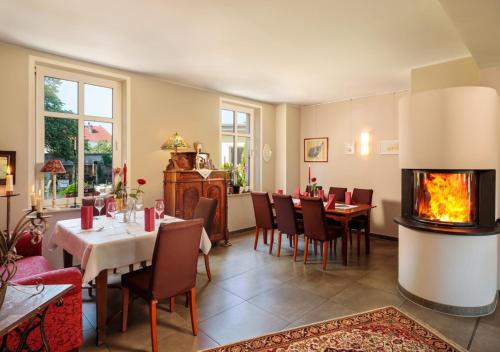 a restaurant with a fireplace in the dining room at Pension EssLust in Niedergörsdorf