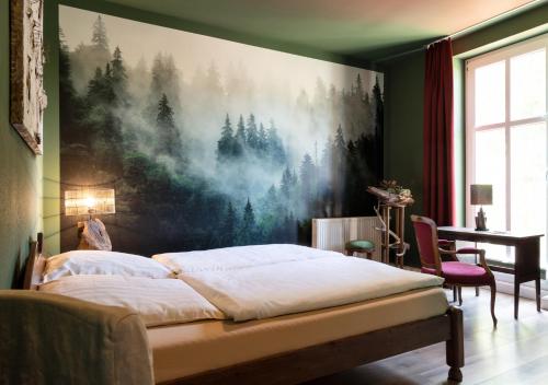 a bedroom with a large painting on the wall at Pension EssLust in Niedergörsdorf