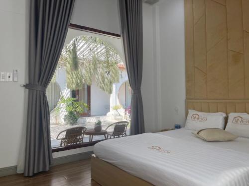 um quarto com uma cama e uma grande janela em Homestay Bingo LaGi 2 em Tân Tạo