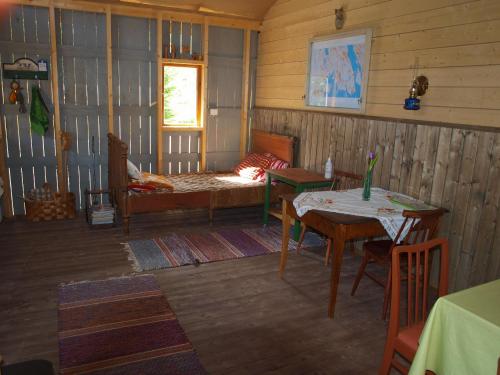 a room with a bed and a table and a table and chairs at Suopirtti bed & breakfast in Konnevesi