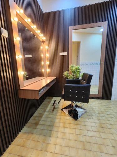 a bathroom with a mirror and a black chair and a desk at Sun Shine Home by Ipoh Maju Stay in Ipoh