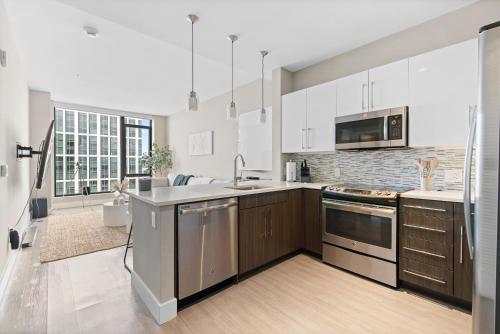 een keuken met witte kasten en een groot raam bij Boston West End Penthouse Edition in Boston
