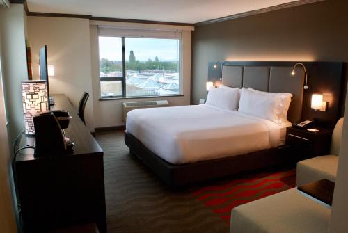 a hotel room with a large bed and a window at Holiday Inn Vancouver Airport Richmond, an IHG Hotel in Richmond