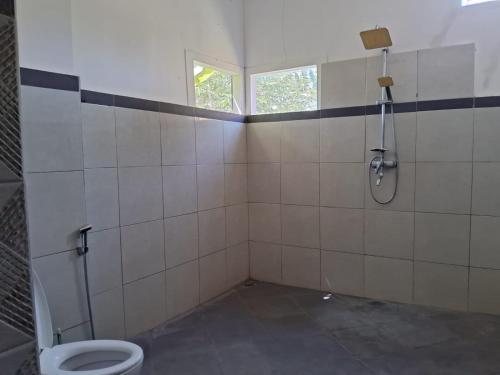 a bathroom with a shower and a toilet at Villa Bamboo Sumbawa in Sumbawa Besar