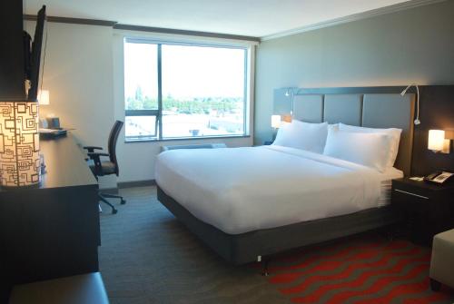 a hotel room with a large bed and a window at Holiday Inn Vancouver Airport Richmond by IHG in Richmond