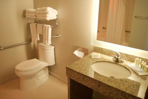 a bathroom with a toilet and a sink and a mirror at Holiday Inn Vancouver Airport Richmond, an IHG Hotel in Richmond