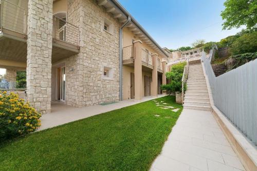 ein Haus mit einem Rasenplatz neben einem Gebäude in der Unterkunft Ferienwohnung für 4 Personen ca 70 m in Torri del Benaco, Gardasee Ostufer Gardasee in Torri del Benaco