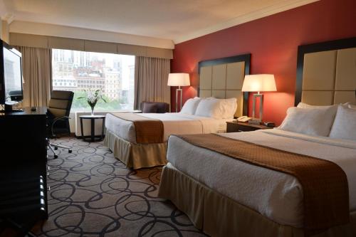 蒙特婁的住宿－蒙特利爾中心城商業區假日酒店，酒店客房设有两张床和窗户。