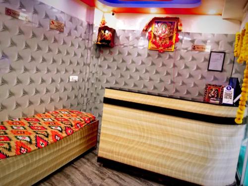 ein Schlafzimmer mit einem Bett und einer weißen Wand in der Unterkunft Hotel Siddhivinayak in Ranchi