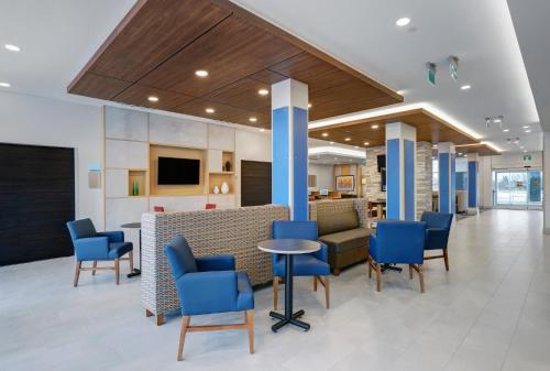 Holiday Inn Express & Suites - Collingwood في كولينغوود: لوبي مستشفى وكراسي زرقاء وطاولة