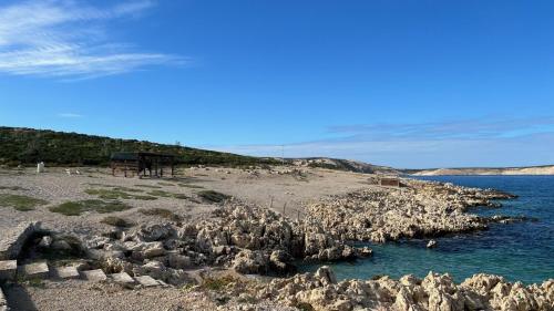 una costa rocciosa con acqua blu e rocce di Fadila a Novalja (Novaglia)