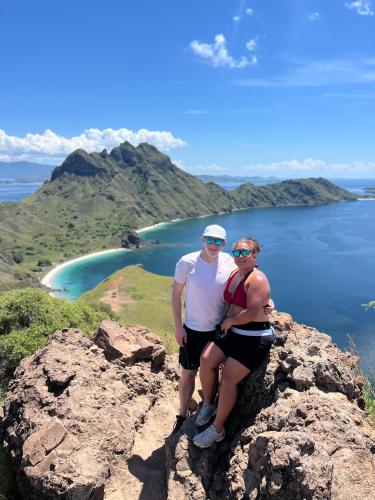 a man and woman sitting on top of a mountain at Jhuna Komodo Homestay in Komodo