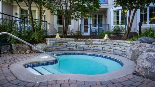 a swimming pool with a stone wall around it at Holiday Inn Express & Suites Tremblant by IHG in Mont-Tremblant