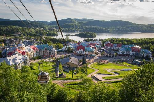a gondola ride over a town with a lake at Holiday Inn Express & Suites Tremblant by IHG in Mont-Tremblant