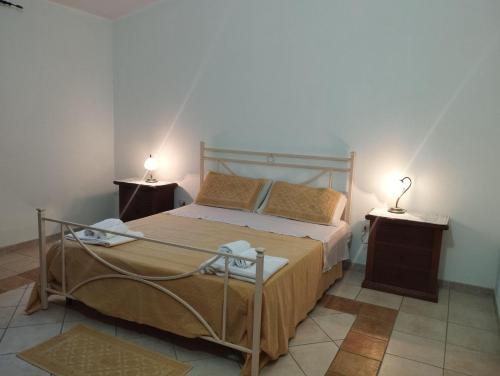 ein Schlafzimmer mit einem Bett mit zwei Nachttischen und zwei Lampen in der Unterkunft Edera Apartment# Tanaunella# Budoni# Beach in Budoni