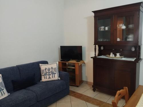 ein Wohnzimmer mit einem blauen Sofa und einem TV in der Unterkunft Edera Apartment# Tanaunella# Budoni# Beach in Budoni