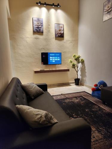 a living room with a couch and a flat screen tv at Sun Shine Home by Ipoh Maju Stay in Ipoh
