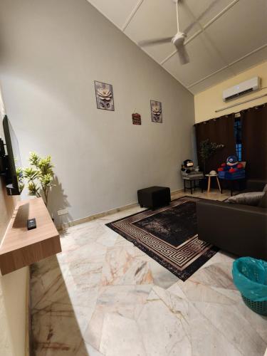 a living room with a couch and a table at Sun Shine Home by Ipoh Maju Stay in Ipoh