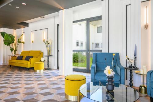 a living room with yellow and blue chairs and a glass table at JOIVY Together Florence Urban Resort in Florence