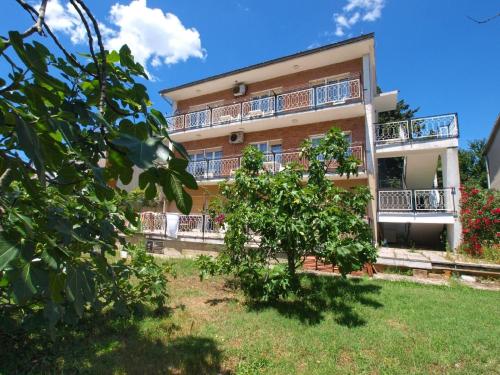 un edificio de apartamentos con balcones y un árbol en Ferienwohnung für 8 Personen ca 100 qm in Pula, Istrien Istrische Riviera, en Pula