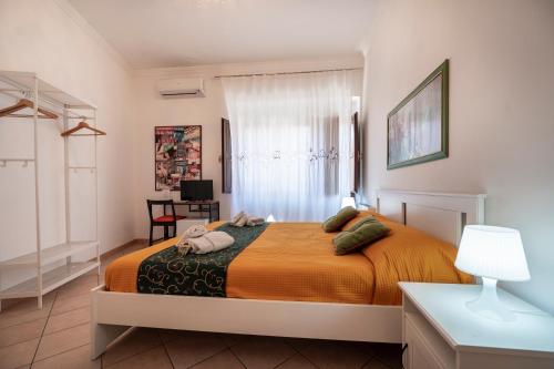 a bedroom with a bed with an orange blanket at Zanzibar - Charming Rooms and Apartments in Avola