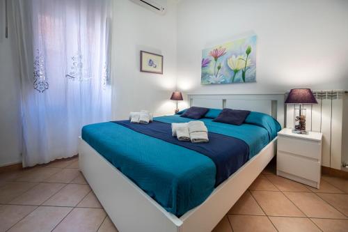 a bedroom with a blue bed with towels on it at Zanzibar - Charming Rooms and Apartments in Avola
