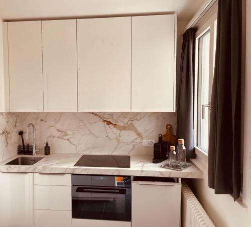 a kitchen with white cabinets and a sink at Villa Sophia in Gerra