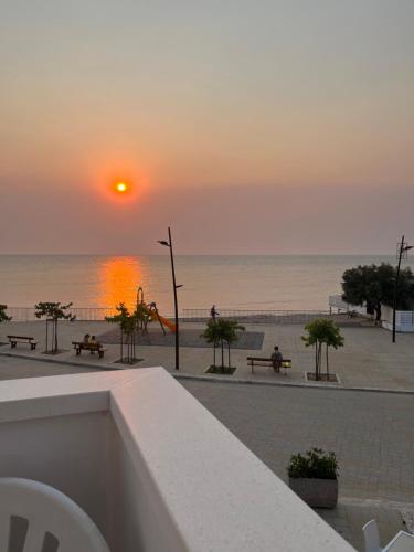 a sunset over a beach with a playground and the ocean at Vista Mare in Torre San Gennaro