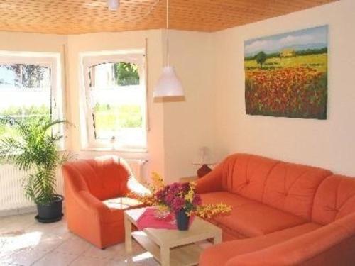 sala de estar con sofá naranja y mesa en Ferienwohnung für 6 Personen ca 68 qm in Daun-Weiersbach, Rheinland-Pfalz Moseleifel en Daun