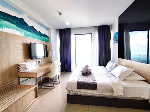 Dormitorio con cama, escritorio y TV en GentingTop SunriseColdSty2R2B8Pax at GrdIonDelmn, en Genting Highlands