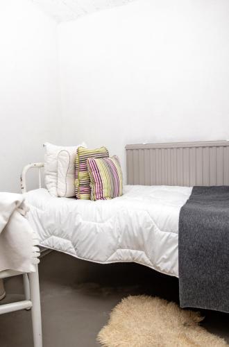 a bed with white sheets and pillows in a room at Vivante Basement Accommodation in Porvoo