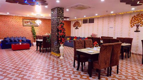 um restaurante com mesas e cadeiras num quarto em Aradhana inn em Lucknow