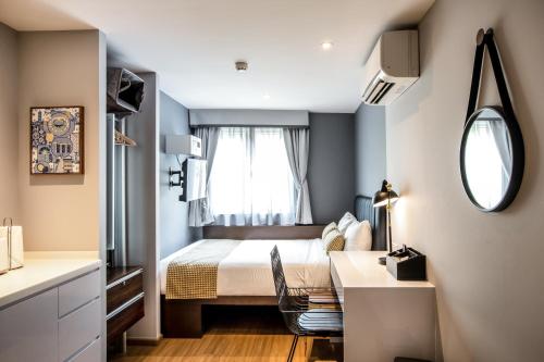 um pequeno quarto com uma cama e uma janela em Heritage Collection on Clarke Quay - A Digital Hotel em Singapura