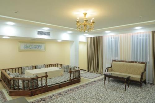 - un salon avec un canapé, une baignoire et un lustre dans l'établissement GREAT SILK ROAD HOTEL, à Ferghana