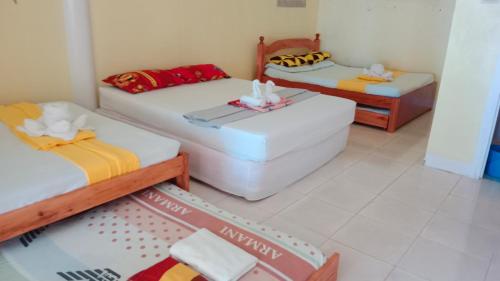 Zimmer mit 2 Betten und 2 Ottomanen in der Unterkunft Ricks Mangrove Beach Resort in Maricaban