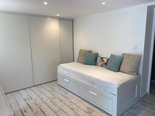 a bedroom with a bed with white walls and cabinets at L’Oliveraie du Revest in Le Revest-le-Eaux