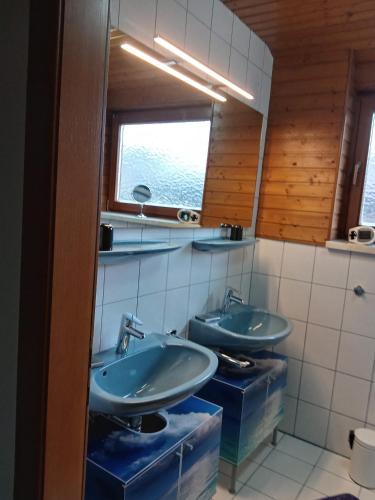 a bathroom with two sinks and a window at Ferienwohnungen Miklautsch in Faak am See