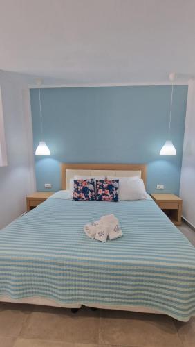 a bedroom with a large bed with a blue wall at Studio Mare Faliraki in Faliraki