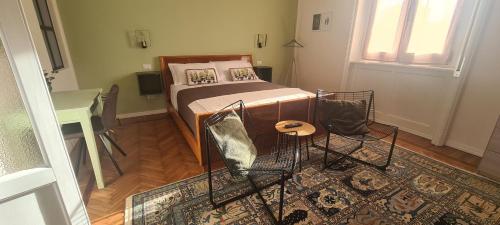 1 dormitorio con cama, mesa y alfombra en Dimora Manzoni en Busto Arsizio