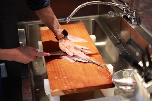 a person cutting a fish on a cutting board at KiCHi - Vacation STAY 15503 in Awaji