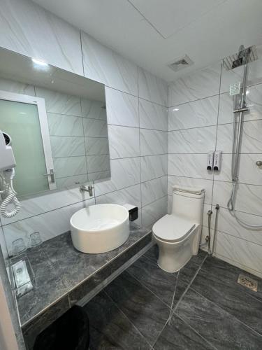 a bathroom with a sink and a toilet and a mirror at 52 The Grace hotel in Muar