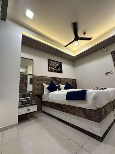 a bedroom with a large bed with a ceiling fan at HOTEL E CLASSICO in Bhavnagar