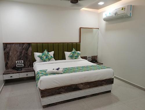 a bedroom with a bed with a cat laying on it at HOTEL E CLASSICO in Bhavnagar