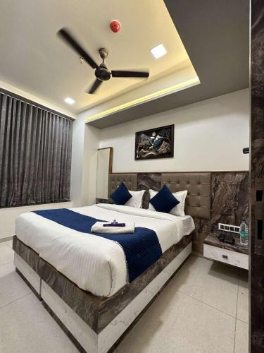 a bedroom with a large bed with a ceiling fan at HOTEL E CLASSICO in Bhavnagar