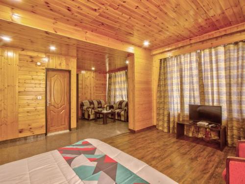 een woonkamer met een bed en een televisie in een kamer bij Royal Pam in Puri