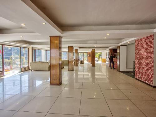 een grote lobby met een tegelvloer en grote ramen bij Royal Pam in Puri